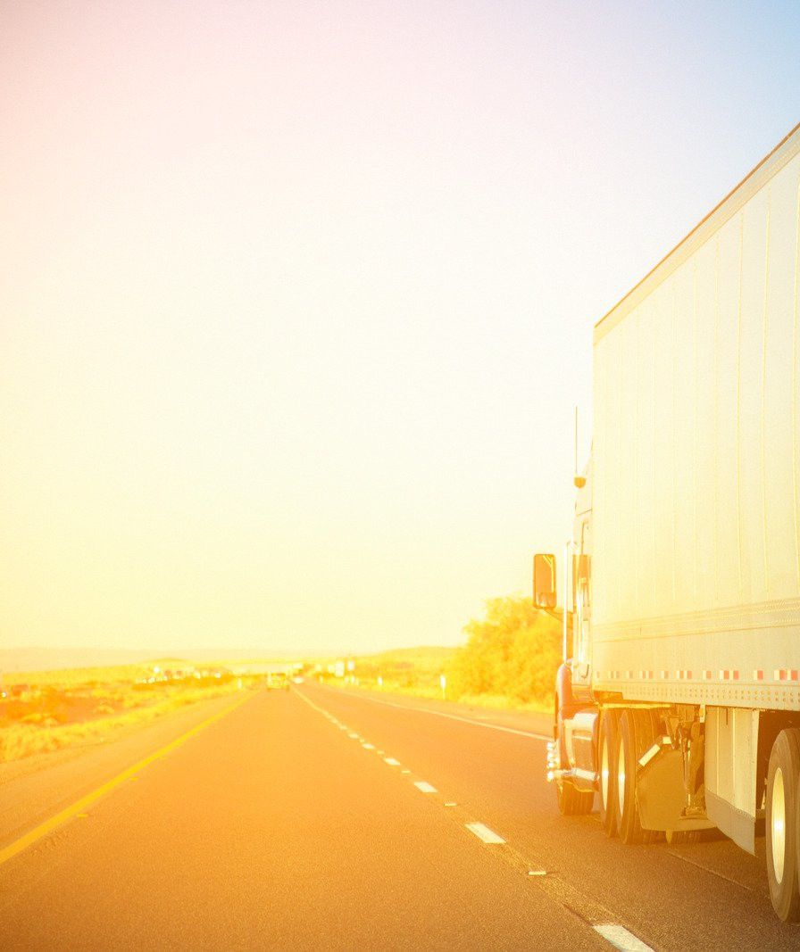 Semi truck driving down the interstate at sunrise